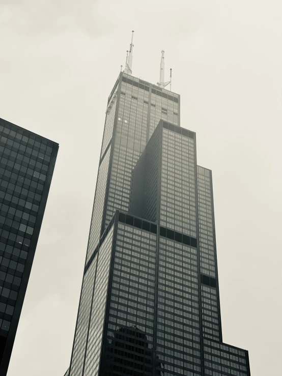 two large buildings next to each other in a cloudy sky