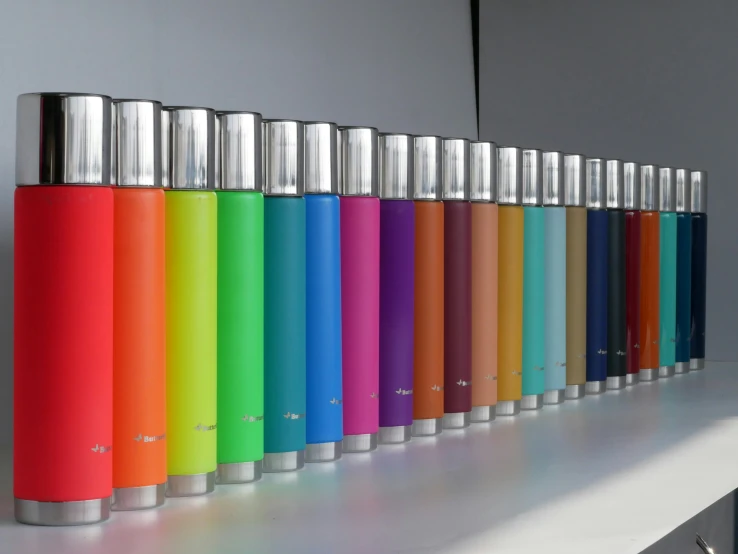 a row of various colored bottles next to each other