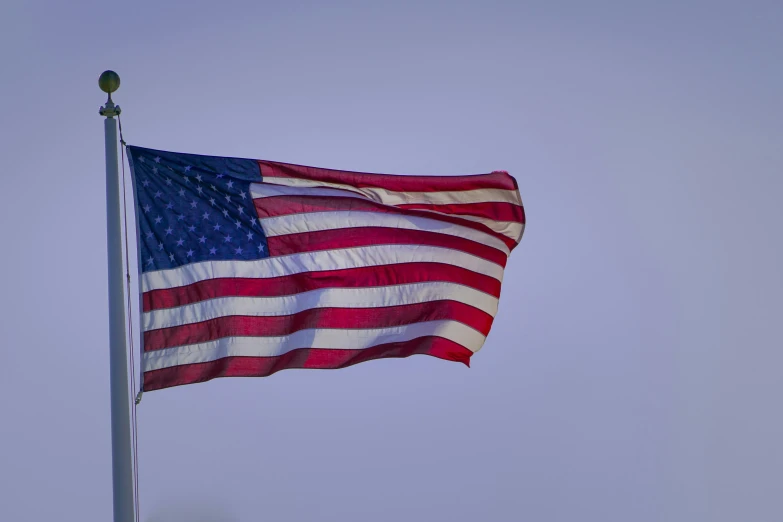 the american flag flying in the sky during daytime