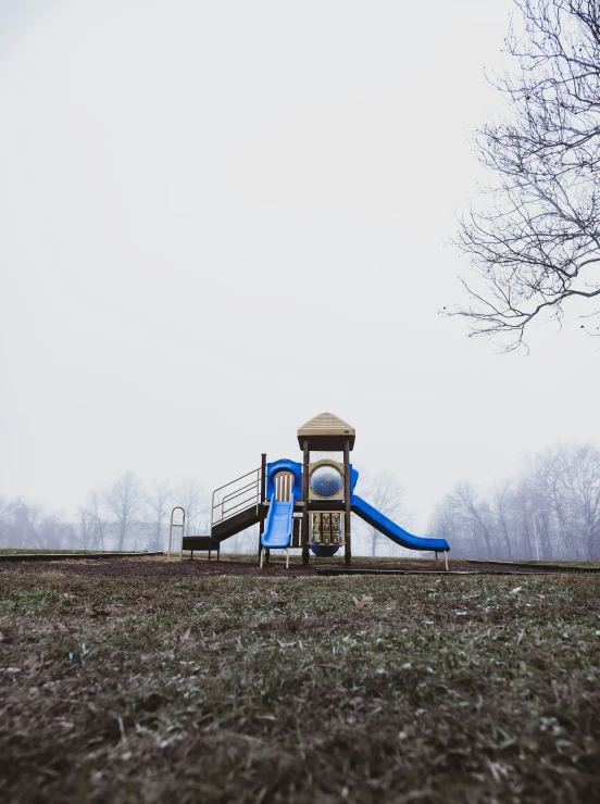 an empty park with a small blue and white playground