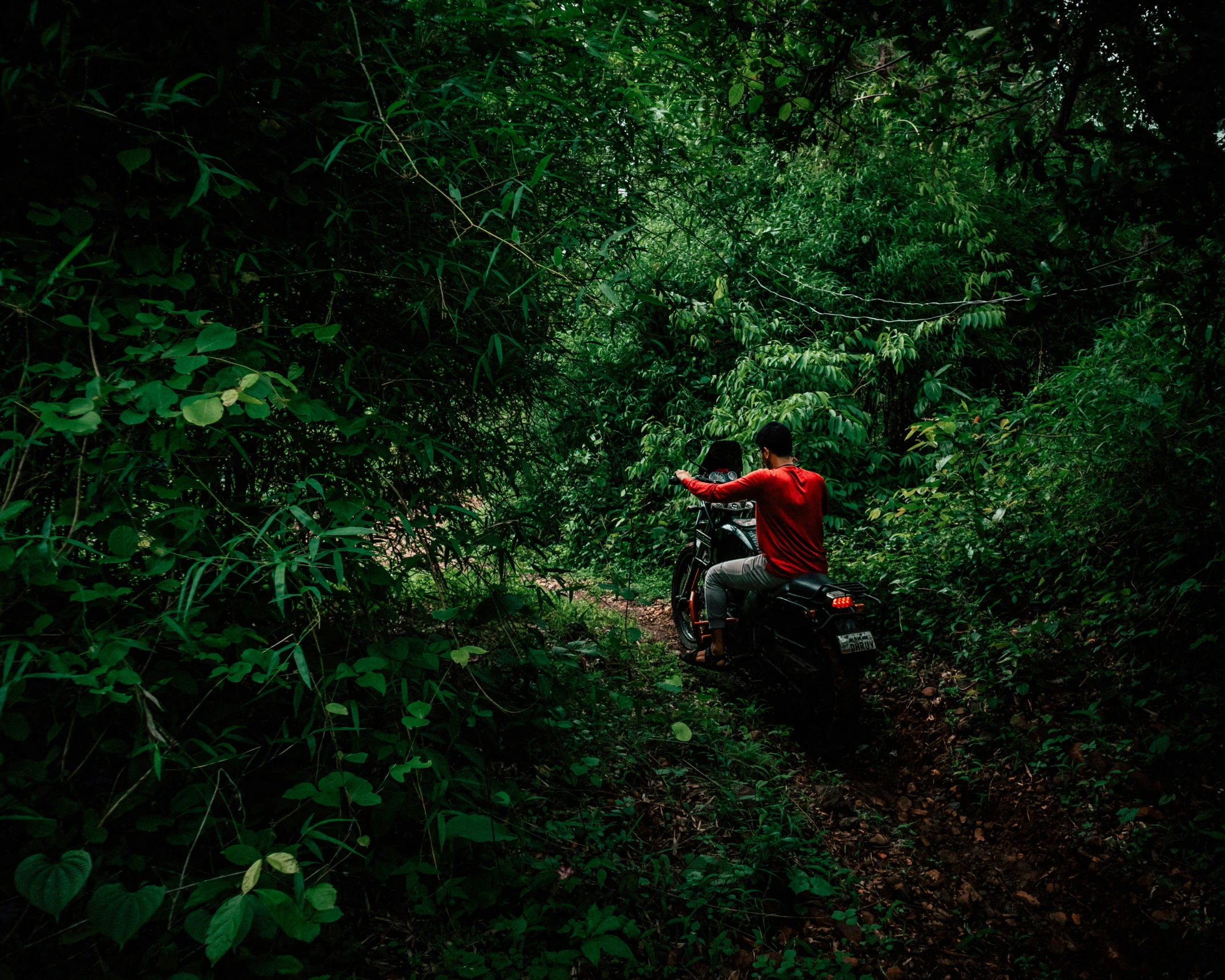 a man on a motor bike driving down a dirt road