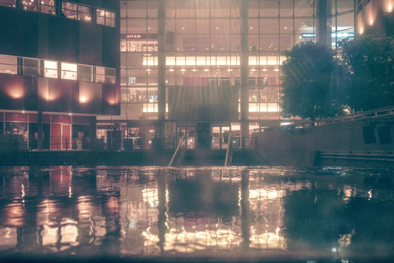 a clock tower standing behind a building at night