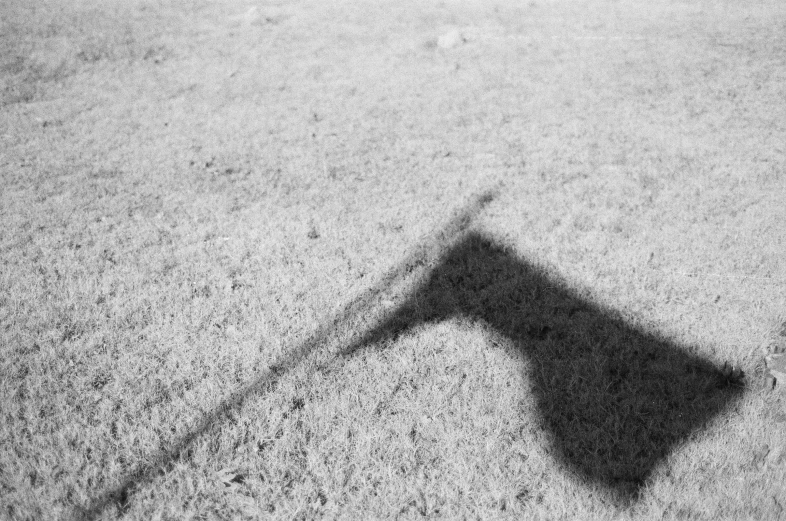 black and white pograph of shadow from a pole on concrete