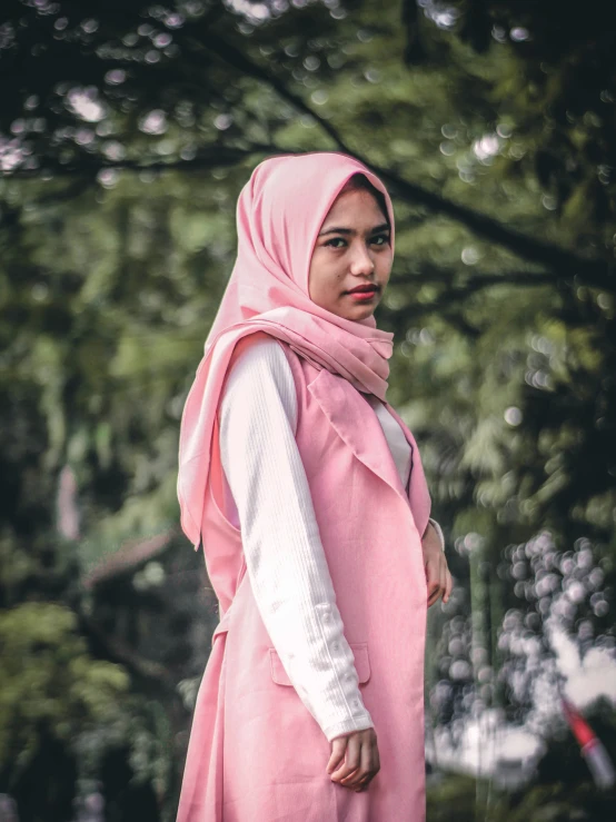 a person standing with a pink head scarf