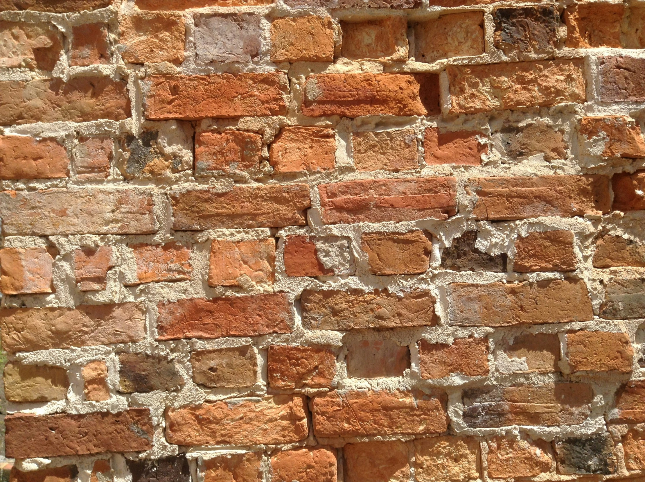 a close up of a brick wall with various colored bricks