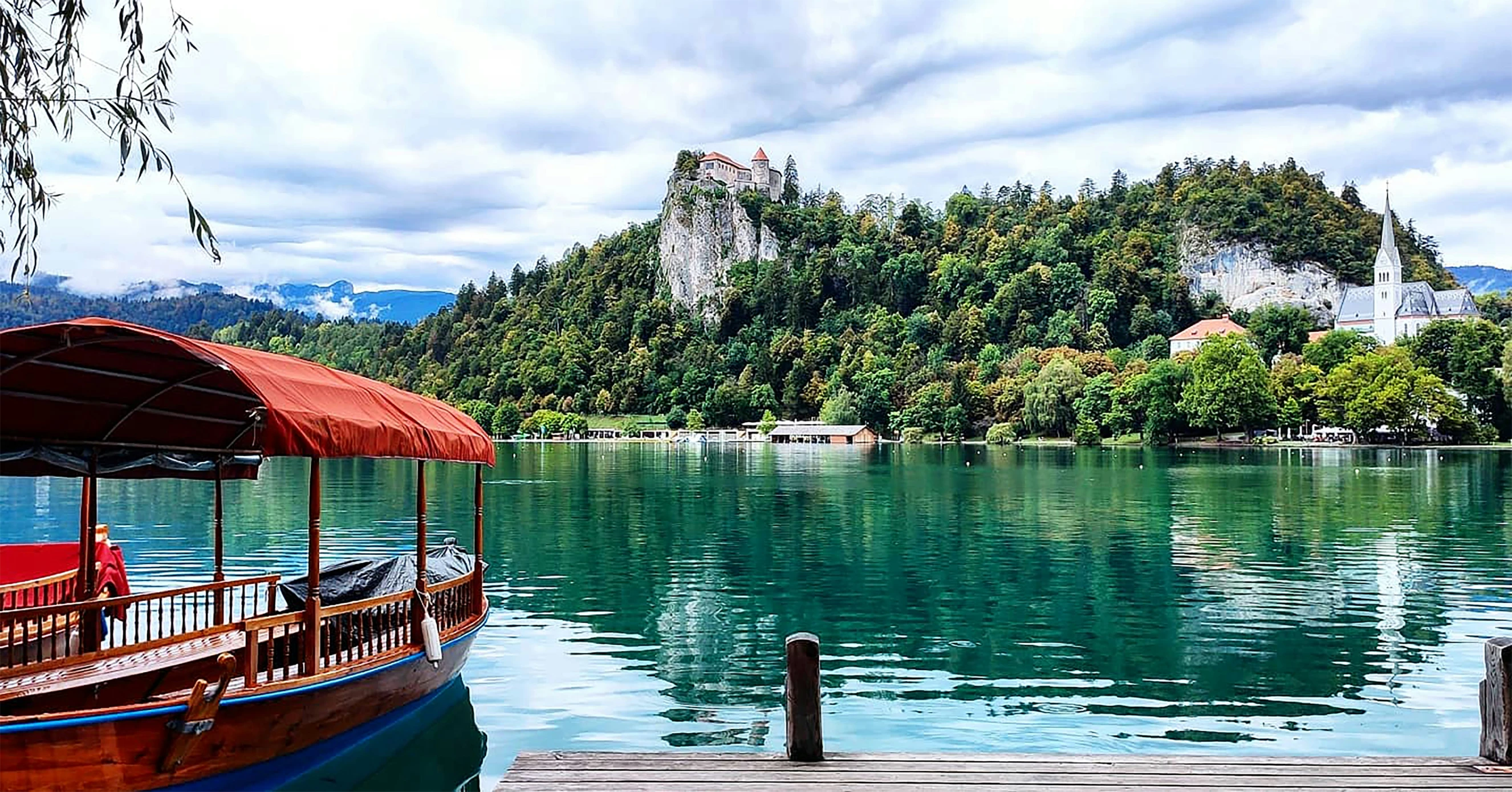 a boat in the water at a lake next to a forest