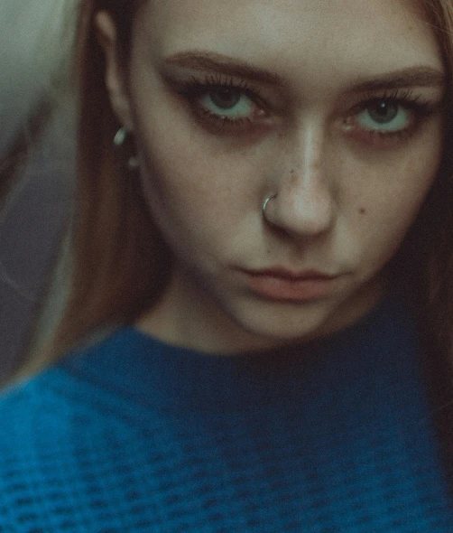 a girl with teary nose and blue sweater