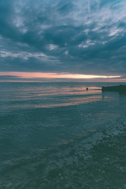 a beach with the sun shining brightly in front of the ocean