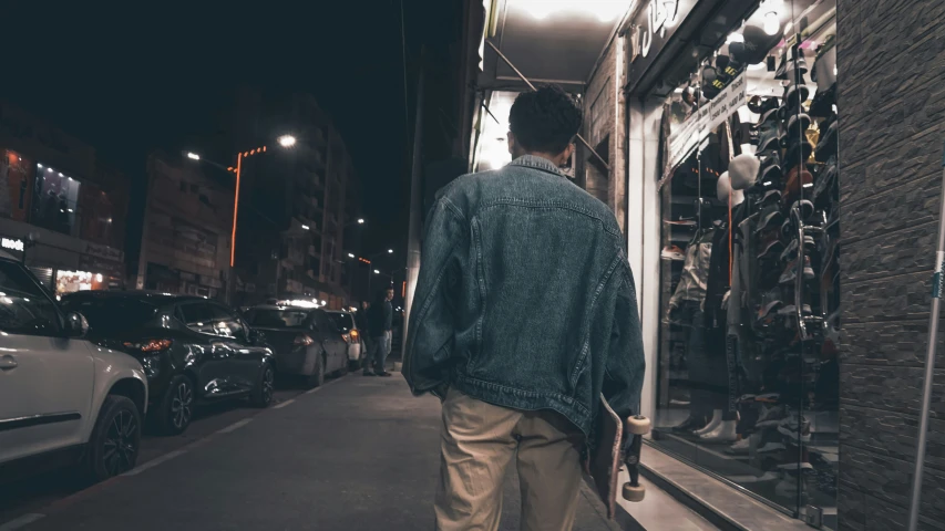 the man is walking down the sidewalk beside his store