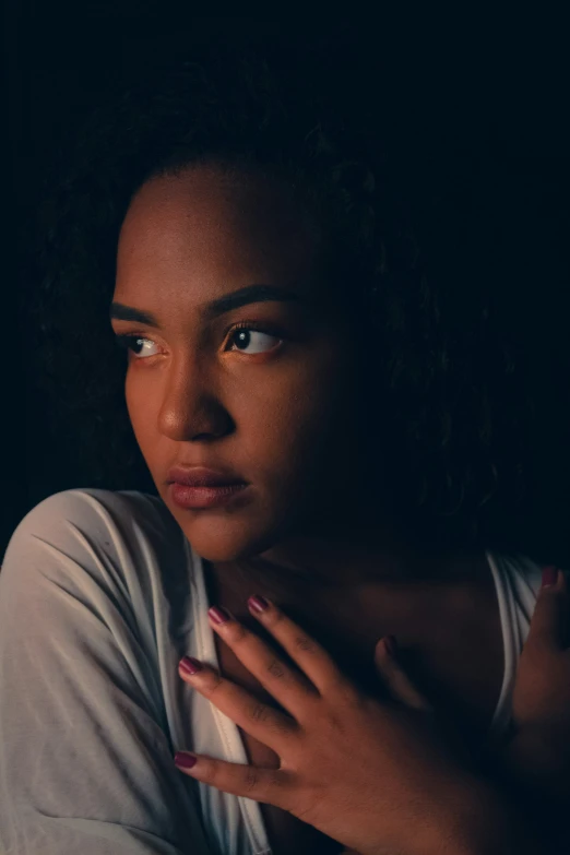 a woman wearing white shirt and holding her hands together