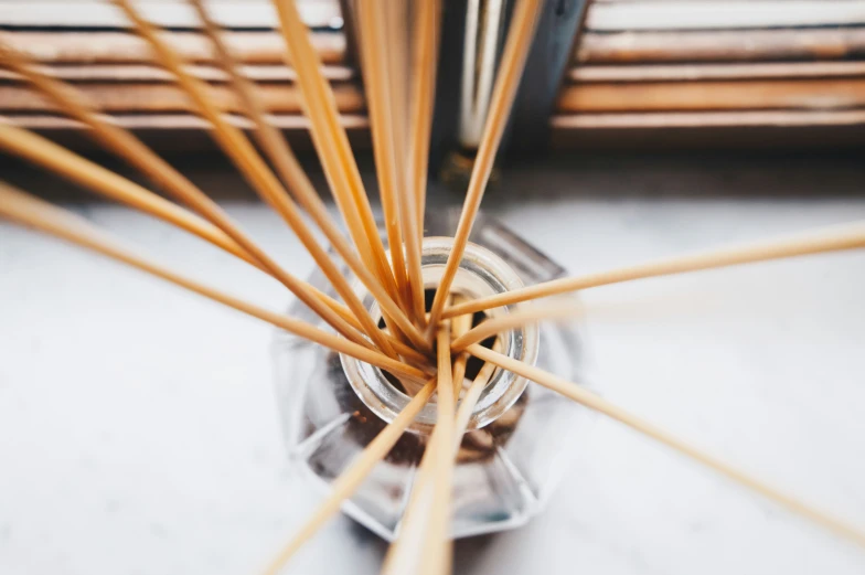 a jar full of wooden sticks with some kind of liquid