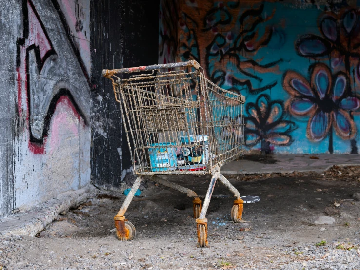 an old shopping cart is leaning against a painted wall