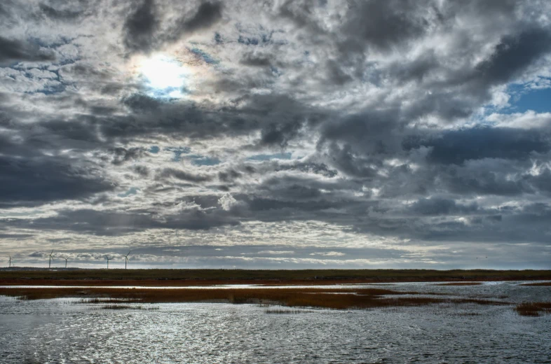 there are clouds in the sky over a body of water