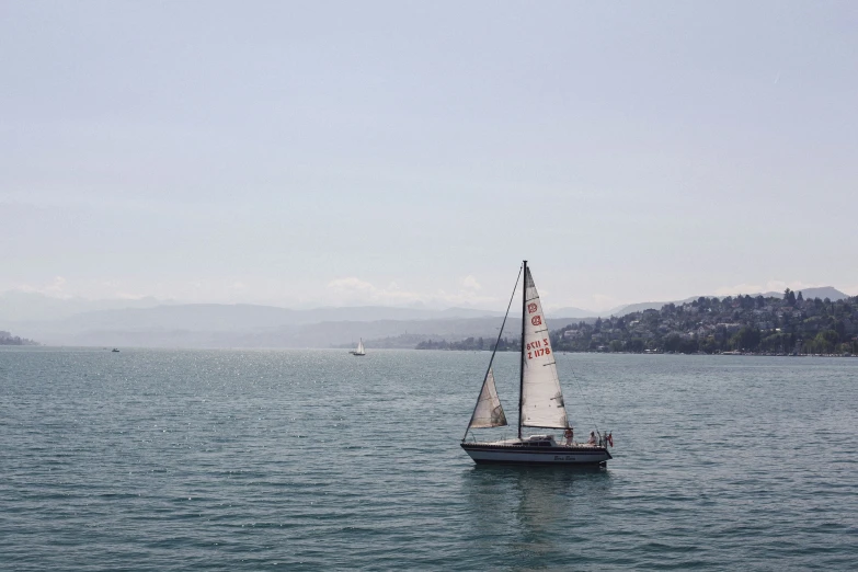 a sail boat floating on top of the ocean