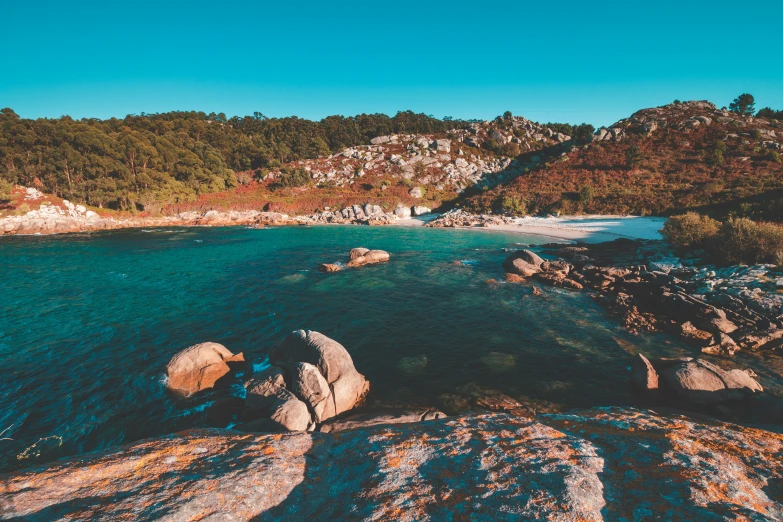 an aerial view of a beach and rocks at the shore