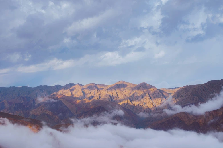 mountains rise above the clouds and fog in the foreground