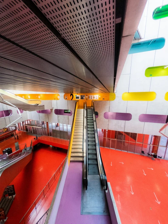 an escalator is pictured with rainbow colors on the carpet