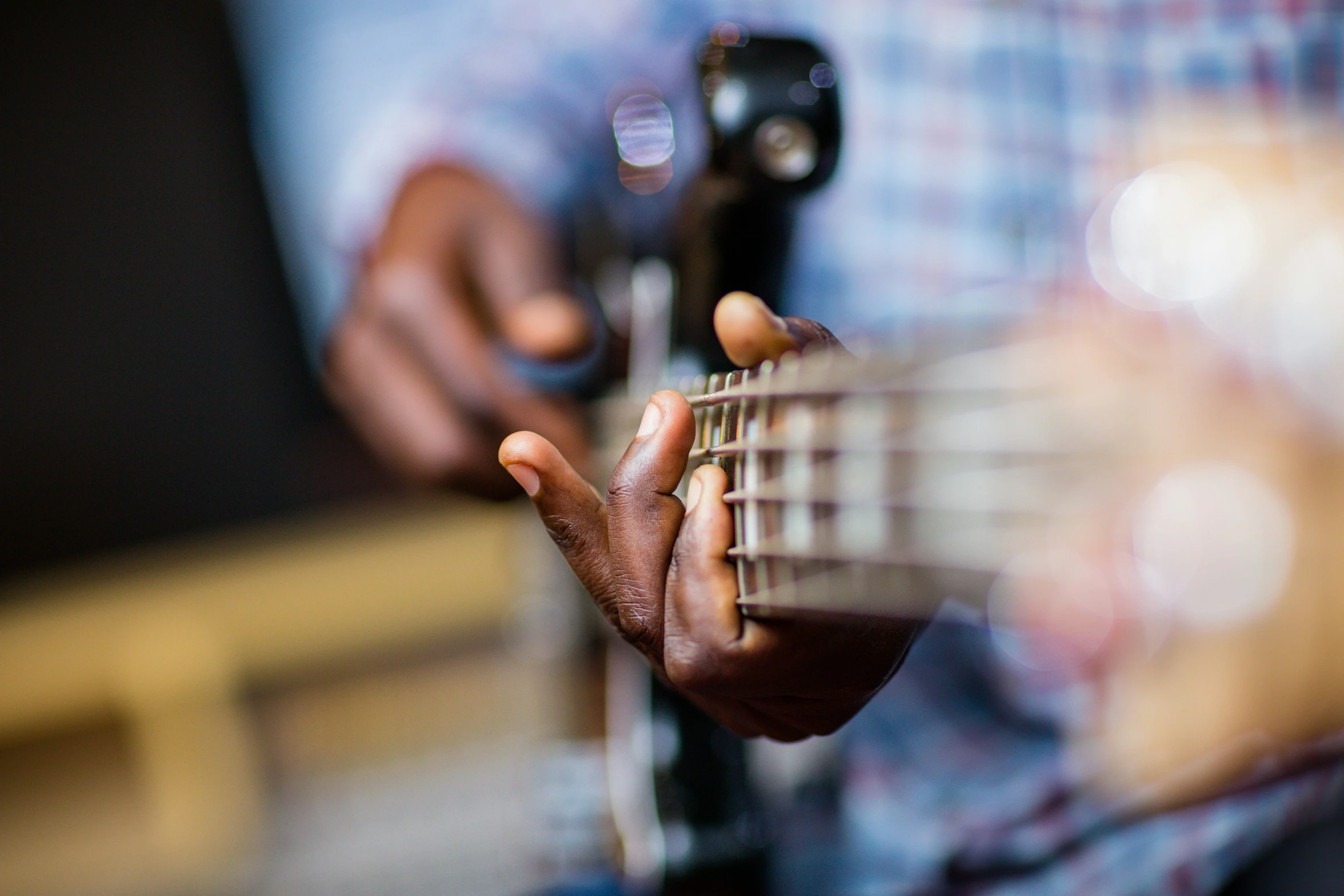 someone is playing the guitar and it has their fingers on top of it