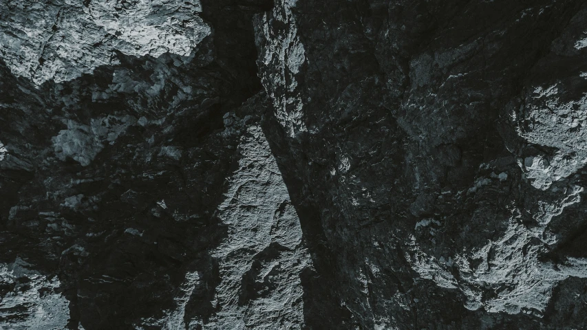 the top portion of a rocky mountain with very thick ridges and a white dot on it