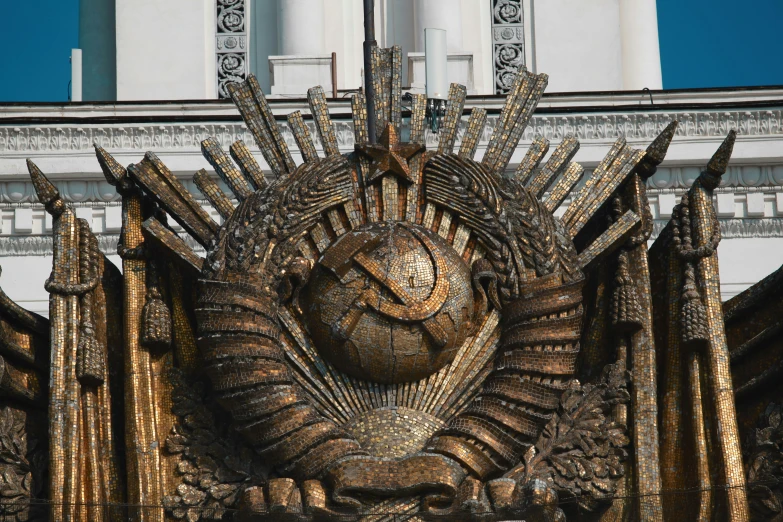 a sculpture of the sun with golden nails