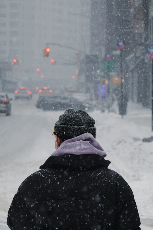 the man is watching the cars in the snow