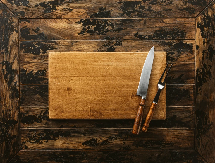 knife on top of wooden  board on wood table