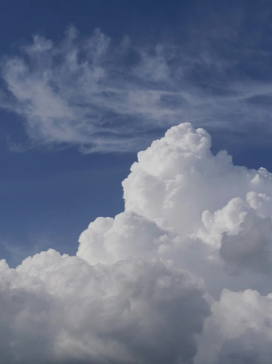 an airplane flies in the sky with white clouds