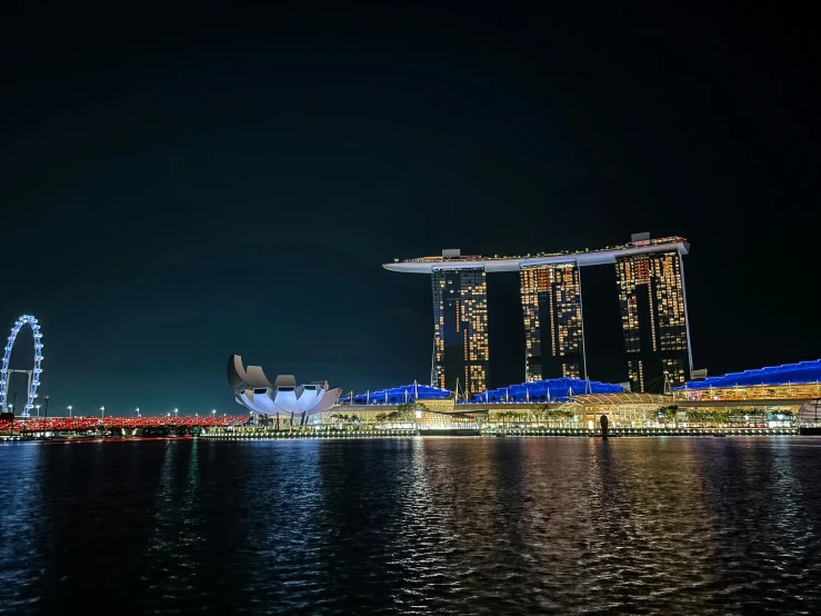 night scene of tall buildings and lights along the river