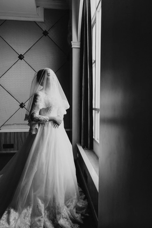 a bride stands in a doorway looking out at the scenery