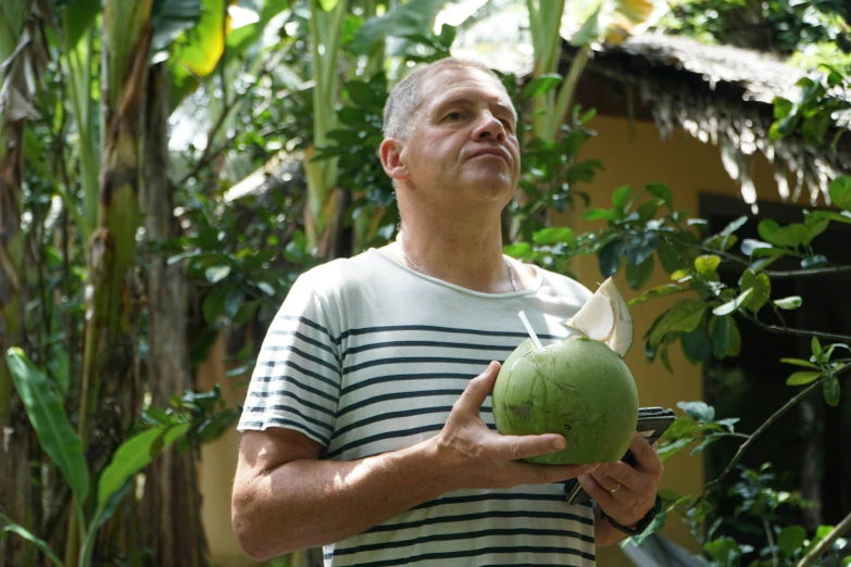 a man holding a big piece of green fruit