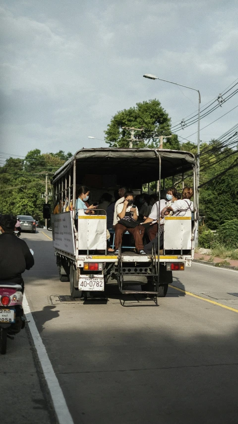 a group of people riding on top of a bus