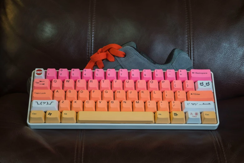 a shoe sits atop a colorful keyboard that sits on a black chair