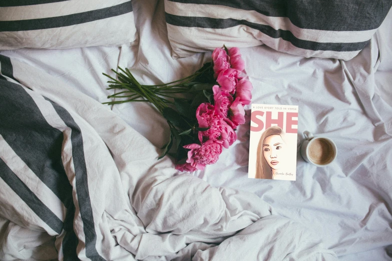 the book and flowers are laid out on the bed