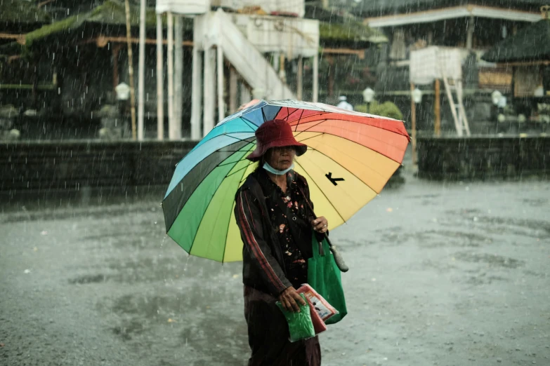 woman walking on wet road holding an umbrella