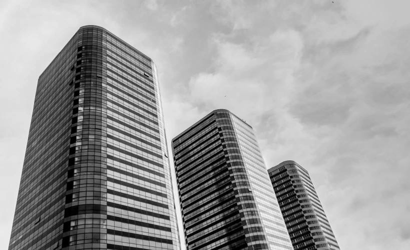 several tall buildings with windows and dark clouds