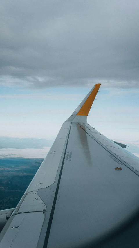 the wing of an airplane and some clouds