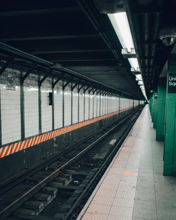 the subway station has a yellow and white striped sign at the end