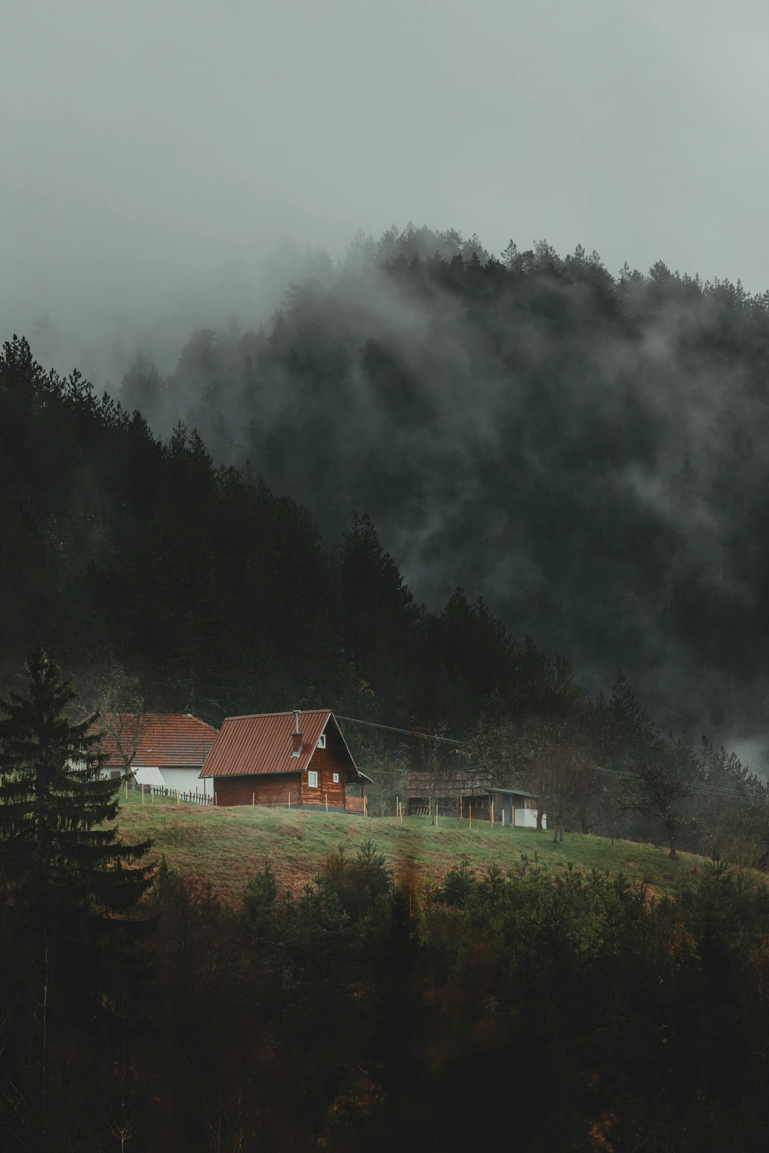 an image of a barn on a foggy hill