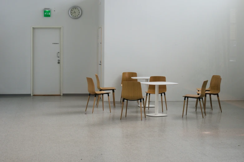 five chairs and two tables in an open room