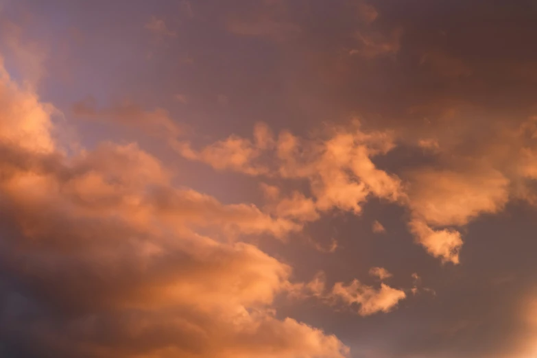 a plane flying over the sky with clouds