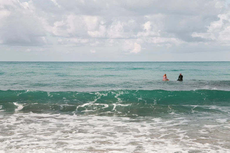 two people are riding surfboards in the ocean