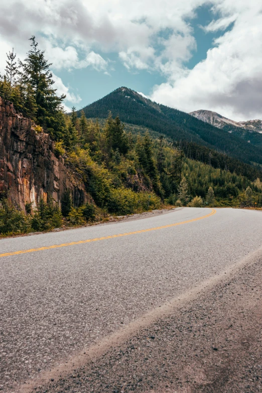 a road running down the side of a cliff in the mountains