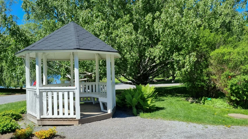 a small white structure sits in front of some trees