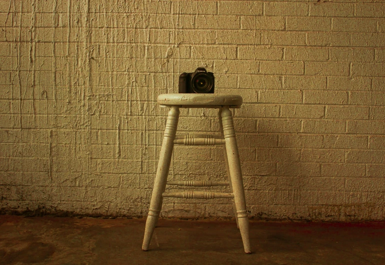 the stool has a camera and a book on top