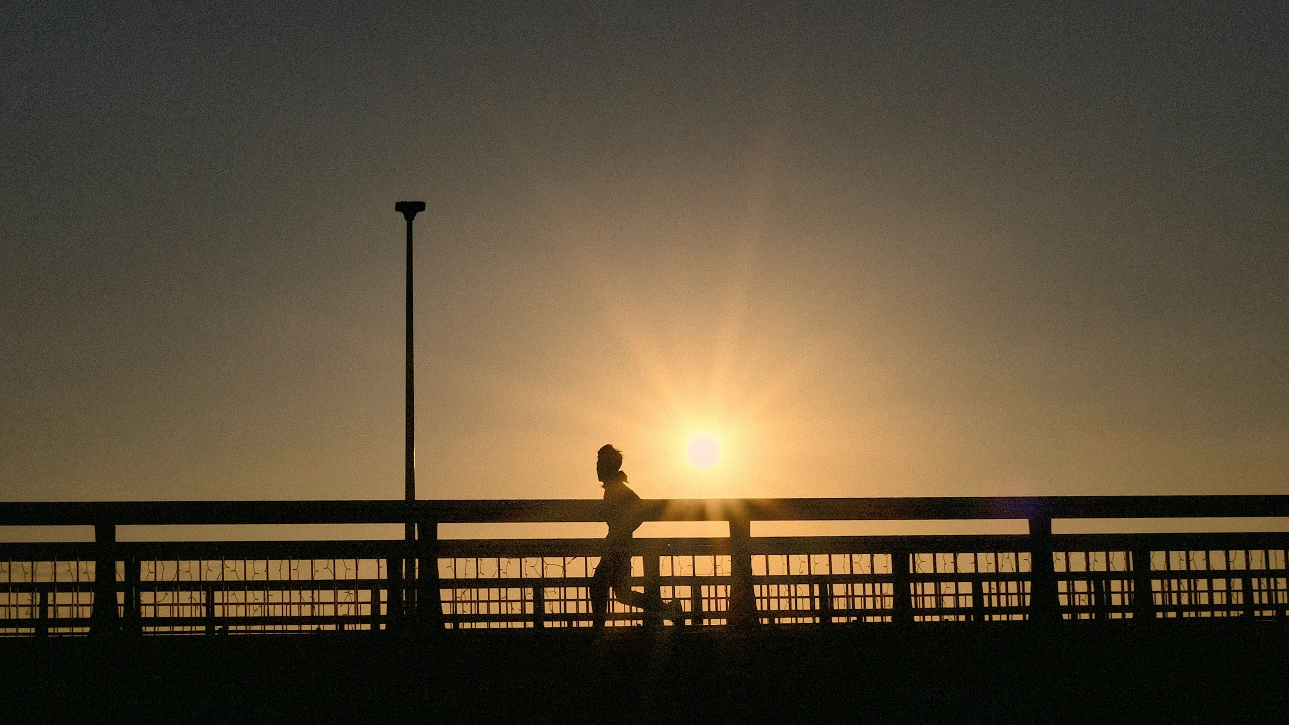 a person on a bridge at sunset