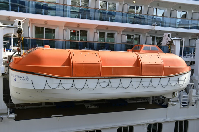 the side of a cruise ship with an orange cover on it