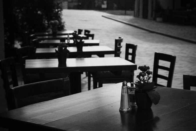 a black and white picture of tables and chairs with flowers