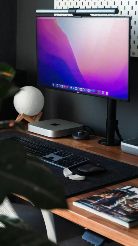 a monitor with purple screen and keyboard