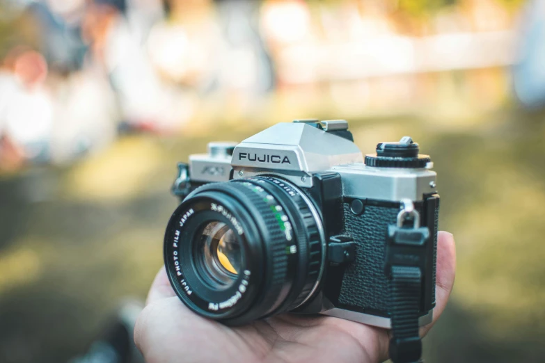 a person holding an old fashioned camera