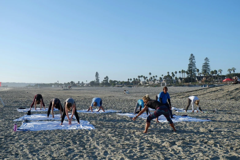 some people who are preparing their snowboards on the beach